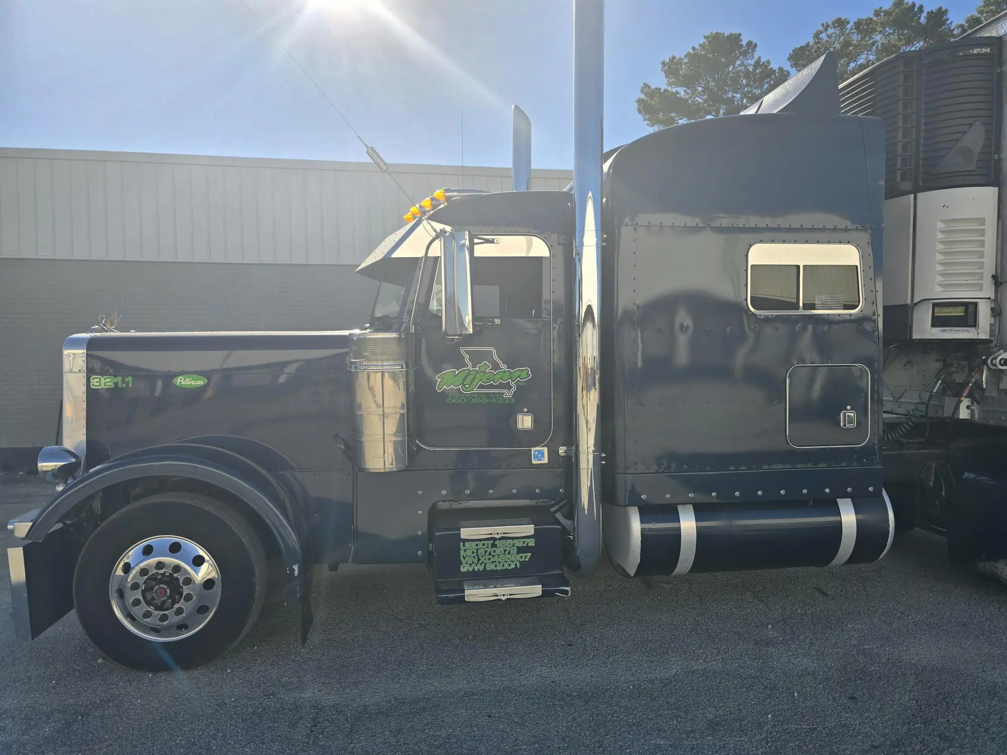 Blue semi-truck parked in sunlight